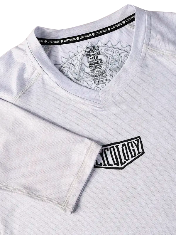 Close-up of a gray V Neck MTB Jersey with a  small Cycology logo on the chest